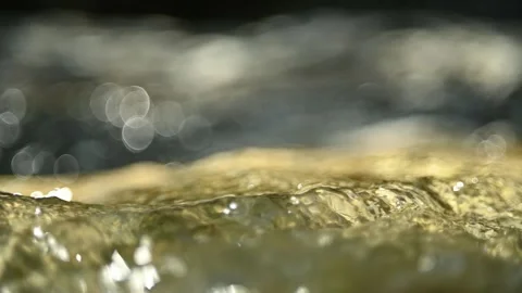 Bokeh of sunlight reflections behind flowing water in the mountains, slow motion Stock-Footage 211755532