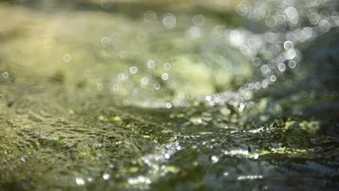 Bokeh of sunlight reflections on flowing water from a mountain stream Video stock 262091089