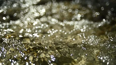 Bokeh of sunlight reflections on the water in a mountain riverbed (slow motion) Stock Footage 211746788