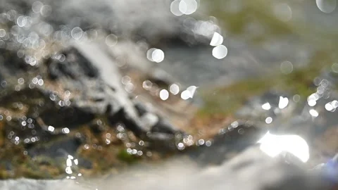 Bokeh of sunlight reflections on wet rocks in the mountains (slow motion) Stock-Footage 219636232