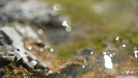 Bokeh of sunlight reflections on wet rocks in the mountains (slow motion) Stock-Footage 219636267