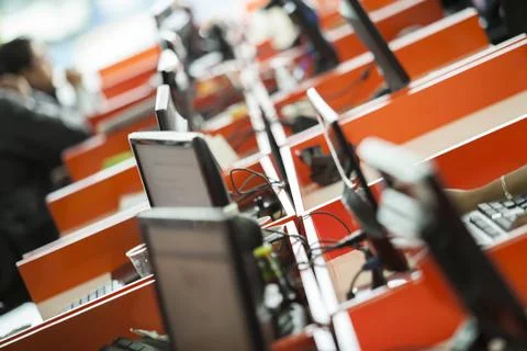 Bokeh telephoto of multiple computers set up people working focus Foto stock