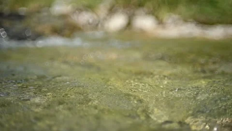 Bokeh of water from a mountain stream flowing in the evening (slow motion) Video stock 260843546