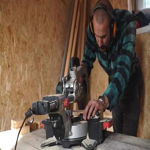 Bold carpenter with moustache Using Circular Saw for wood in his workshop. Stock Footage 69536931