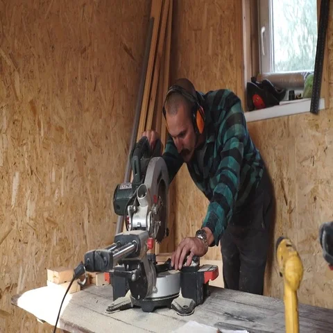 Bold carpenter with moustache Using Circular Saw for wood in his workshop close Stock Footage 69537706