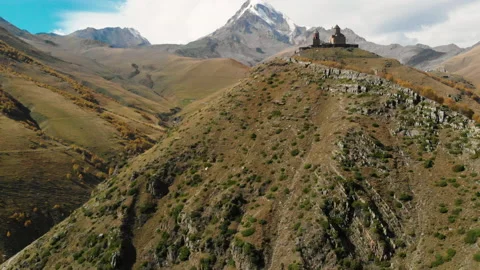 Bold eagle flies past the drone camera with scenic mountains and a church. Epic. Stock Footage