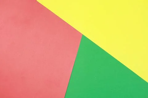 Bold geometric background composed of intersecting red, yellow, and green paper Stock Photos