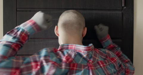 Bold man hits front door repeatedly with growing frustration Stockbeeldmateriaal 314717064