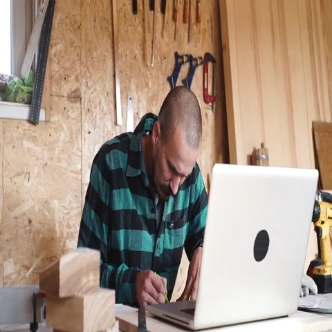 Bold with moustache young Carpenter Craftsman do drawing with laptop in his Stock Footage 69532296