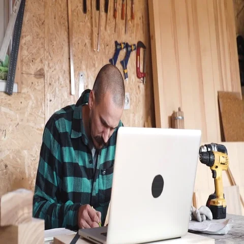 Bold with moustache young Carpenter Craftsman do drawing with laptop in his Stock Footage 69532334
