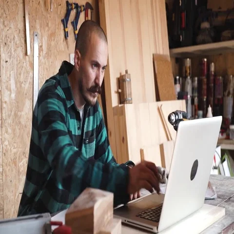 Bold with moustache young Carpenter Craftsman do drawing with laptop in his Stock Footage 69534801
