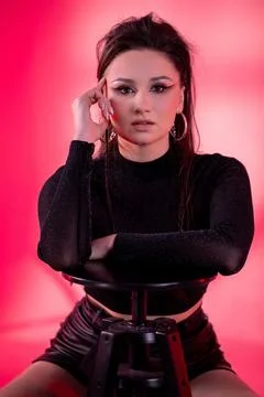A Bold Portrait of a Stylish Model Set Against a Bright Pink Background to Foto stock