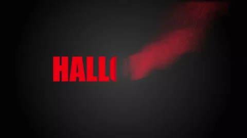 Bold red Halloween lettering dissolves into particles drifting upward and to the Stock Footage 345504875