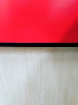 Bold Red Surface Above Textured Light Wood Grain Background. Stock Photos
