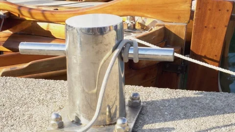 A bollard on the pier in close-up, to which an old sailing yacht Stockbeeldmateriaal 255439447
