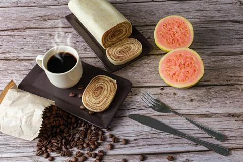 Bolo de rolo slice surrounded by guava, cup and coffee beans (top view). Stock Photos