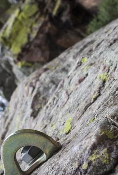 Bolt or parabolt fixed into a hole drilled in the rock full of lichen Stock Photos