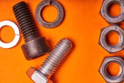 Bolted connecting elements on orange background close-up Stock Photos