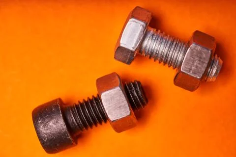 Bolted connecting elements on orange background close-up Stock-Fotos