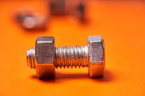 Bolted connecting elements on orange background close-up Stock Photos