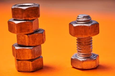 Bolted connecting elements on orange background close-up Stock Photos