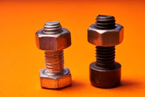 Bolted connecting elements on orange background close-up Stock Photos