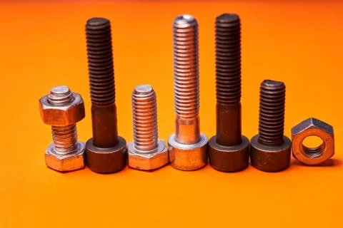 Bolted connecting elements on orange background close-up Stock Photos
