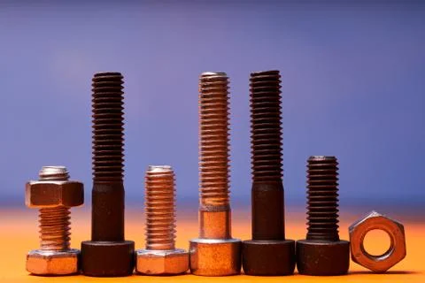 Bolted connecting elements on orange, blue background close-up Stock Photos