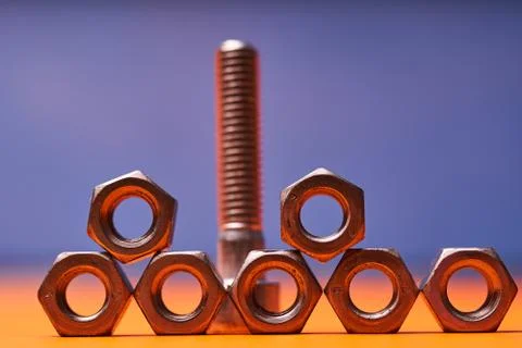 Bolted connecting elements on orange, blue background close-up Foto stock
