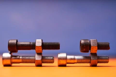 Bolted connecting elements on orange, blue background close-up Stock Photos