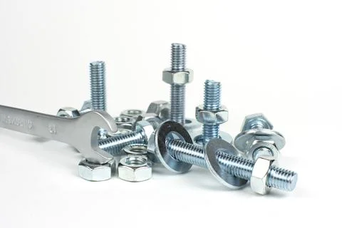 Bolts and nuts on a rough plan with a wrench Stock Photos