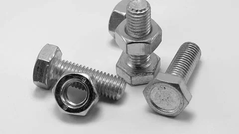 Bolts with nuts rotate in a circle on a white background Stock Footage 197376489