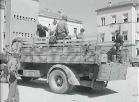 BOLZANO - 1945: Weapons loading - Soldiers load weapons onto a stake-bed truck Stock Footage 343848951