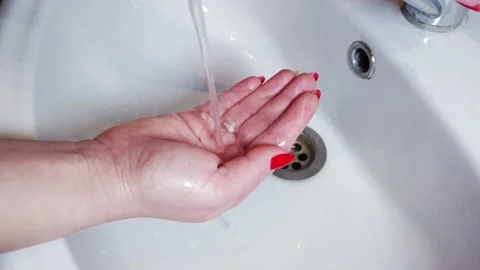 Bomb bath salt dissolves in water and creates foam. A girl holds a bath bomb in Stock Footage 149895406