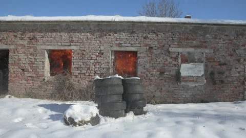 Bomb blast explodes in old brick building with tires stacked outside in Stock Footage 151324437