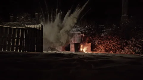 Bomb explodes at night illuminating snow covered street in fiery glow at Video stock 151038639