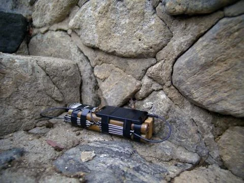BOMB LEFT AT A STONE WALL. Stock Photos