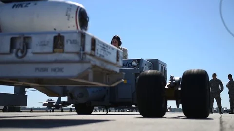 Bomb loader lifting box of weapons during munitions building and loading program Stock Footage 83308412