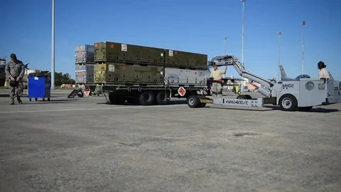 Bomb loader unloads boxes of weapons for munitions building and loading program Stock Footage 83308194
