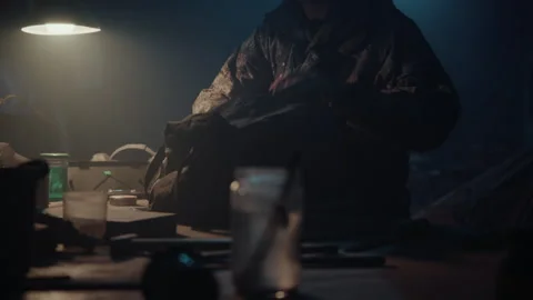 Bomb maker creating an explosive in the warehouse and putting it in a bag Vídeo Stock 256017239