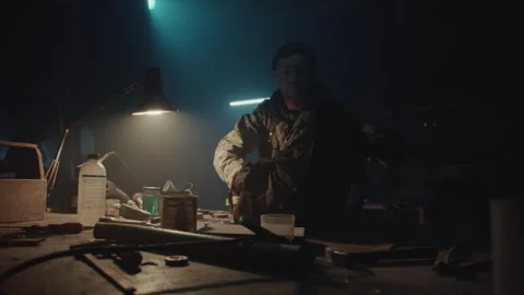 Bomb maker finishing an explosive device and putting it in a bag Stock Footage 256010441