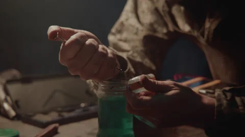 Bomb maker injecting some fluid Stock Footage 259907362