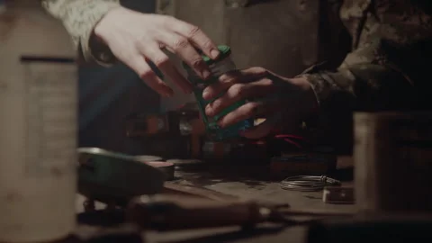 Bomb maker opening a jar with blue liquid in it Vídeo Stock 256012512