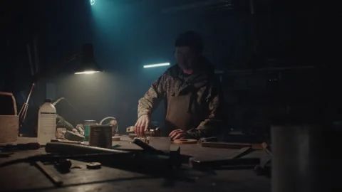 Bomb maker taping a phone to an explosive and getting it ready 스톡 동영상 256013496