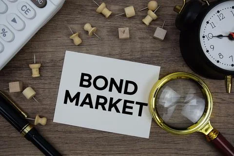 Bond Market text written on notepad with pen, alarm clock, magnifying glass.. Stock Photos