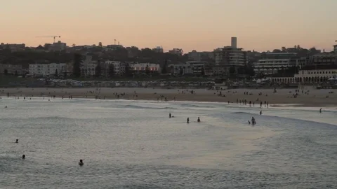 Bondi beach at sunset, overlooking the ocean, people swimming. Stock Footage 85298201