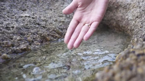 Bonding Assembly. Woman's hand playing with water in a puddle. Slow motion Stock Footage 66761193