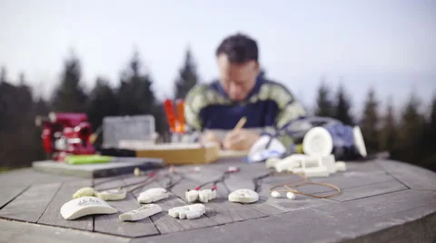 Bone carving master behind a working desk outside 4K Stock Footage 58207404