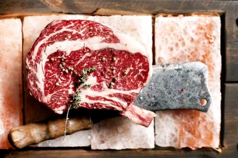 Bone In Rib Eye row Steak on pieces of salt Foto stock