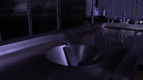 BONE SAW ON AN AUTOPSY TABLE.  EMPTY MORGUE.  4K, 10 BIT SLIDER SHOT. Stock Footage 100167623